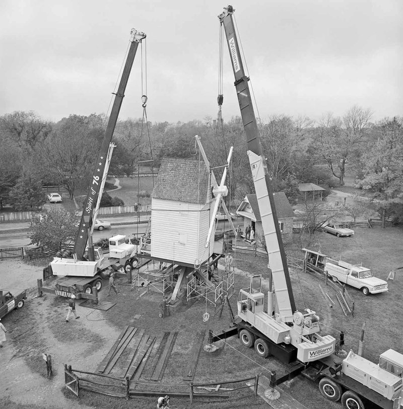 A 1977 black and white photo of the windmill being moved with cranes.