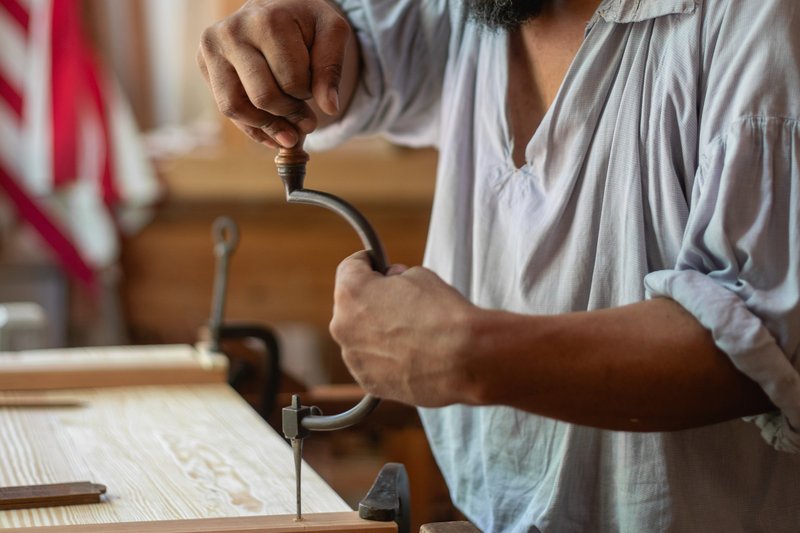 A photo of a joiner helping make a piece of furniture for the Bray School.