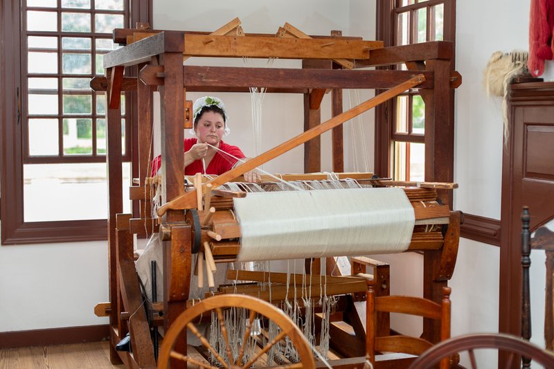 A photo of a weaver weaving textiles for the Bray School.