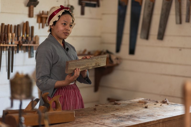 A photo of a cabinetmaker holding a piece of wood.