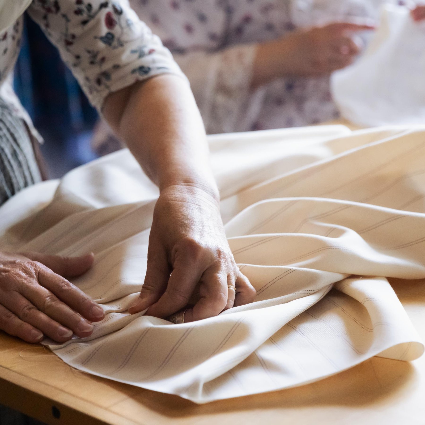 Hands setting pleats in fabric