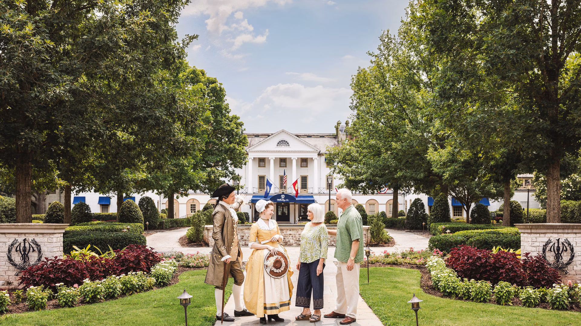 four people standing outside a hotel