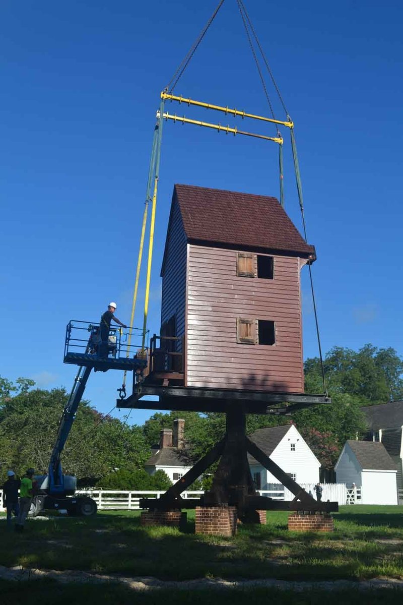 A photo of the windmill being placed on it&#x27;s base in Ewing Field by a crane.