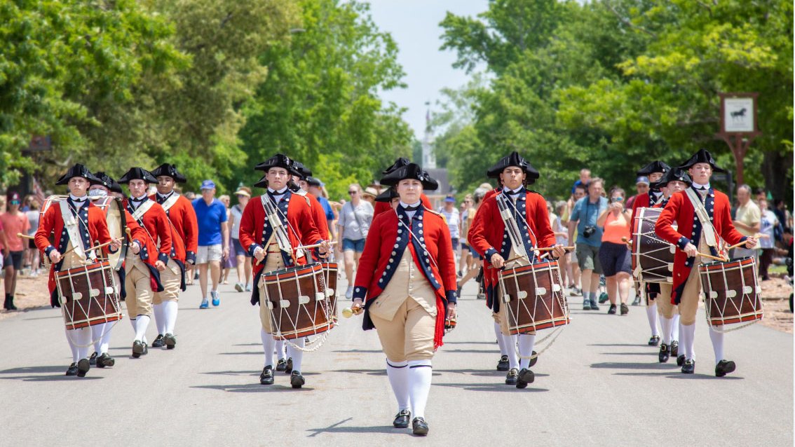 A photo of Colonial Williamsburg's Fife and Drum Corps processing down the Duke of Gloucester Street.
