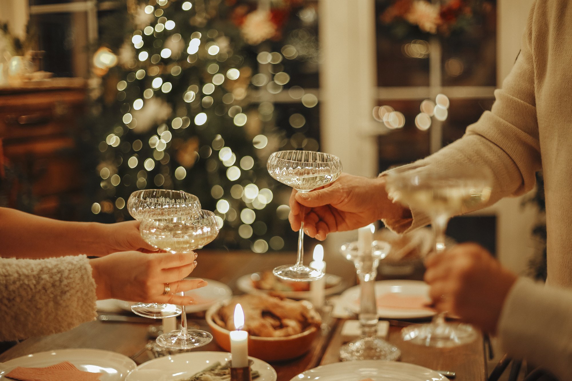 Happy friends clinking champagne glasses while celebrating New Years Eve or Christmas