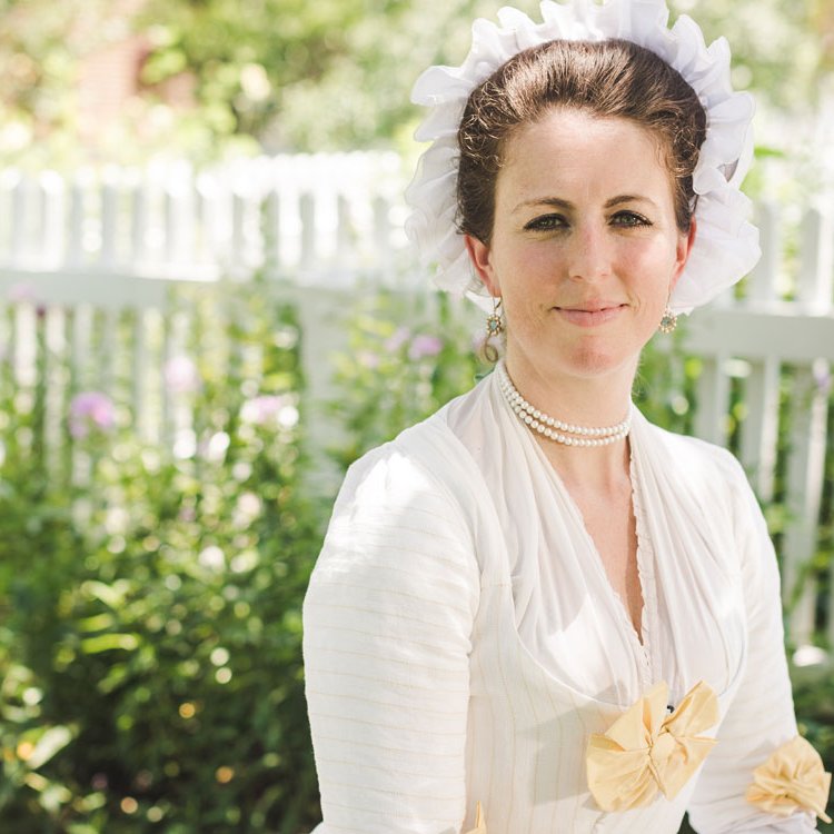 An interpreter dressed as Martha Washington faces forward.