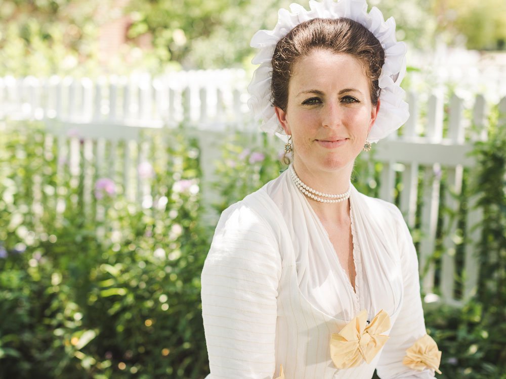 An interpreter dressed as Martha Washington faces forward.