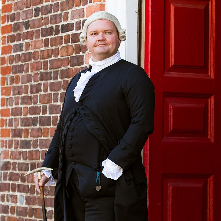 An interpreter dressed as George Wythe faces the camera.