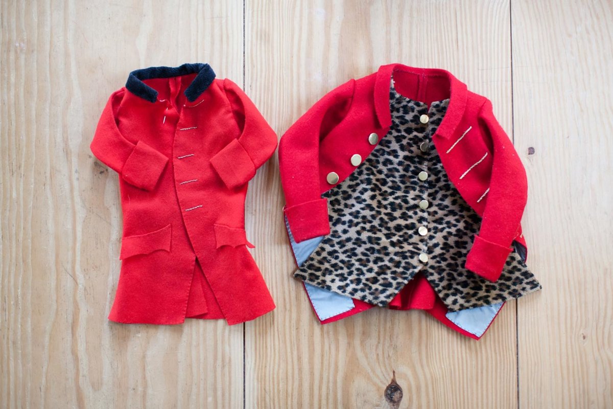 A photo of two small, red garments of clothes intended for a cat.