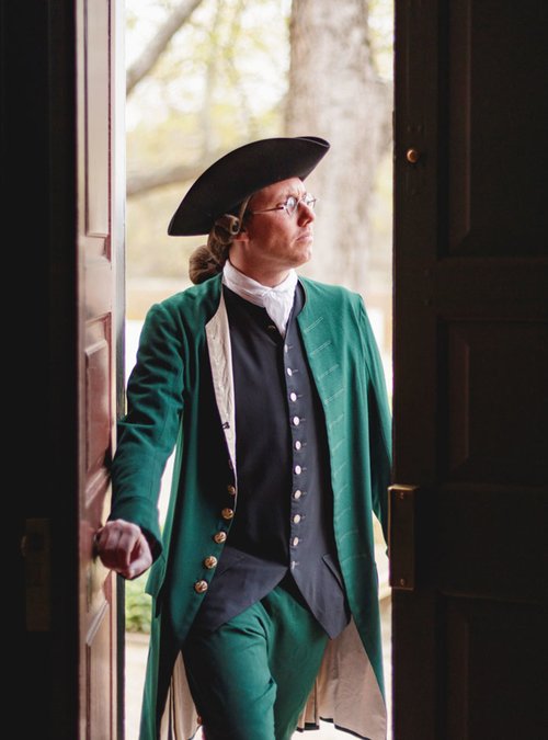 An interpreter dressed as George Mason walks through doorway.