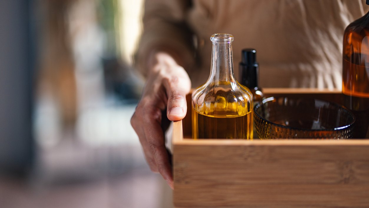 Close Up Shot of an Anonymous Massage Therapist Holding a Tray With Massage Oils and Products