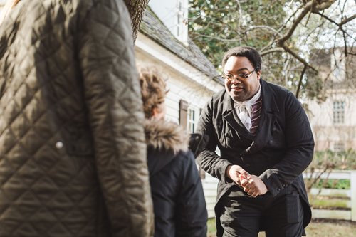 An interpreter dressed asJames Armistead Lafayette speaks with guests.