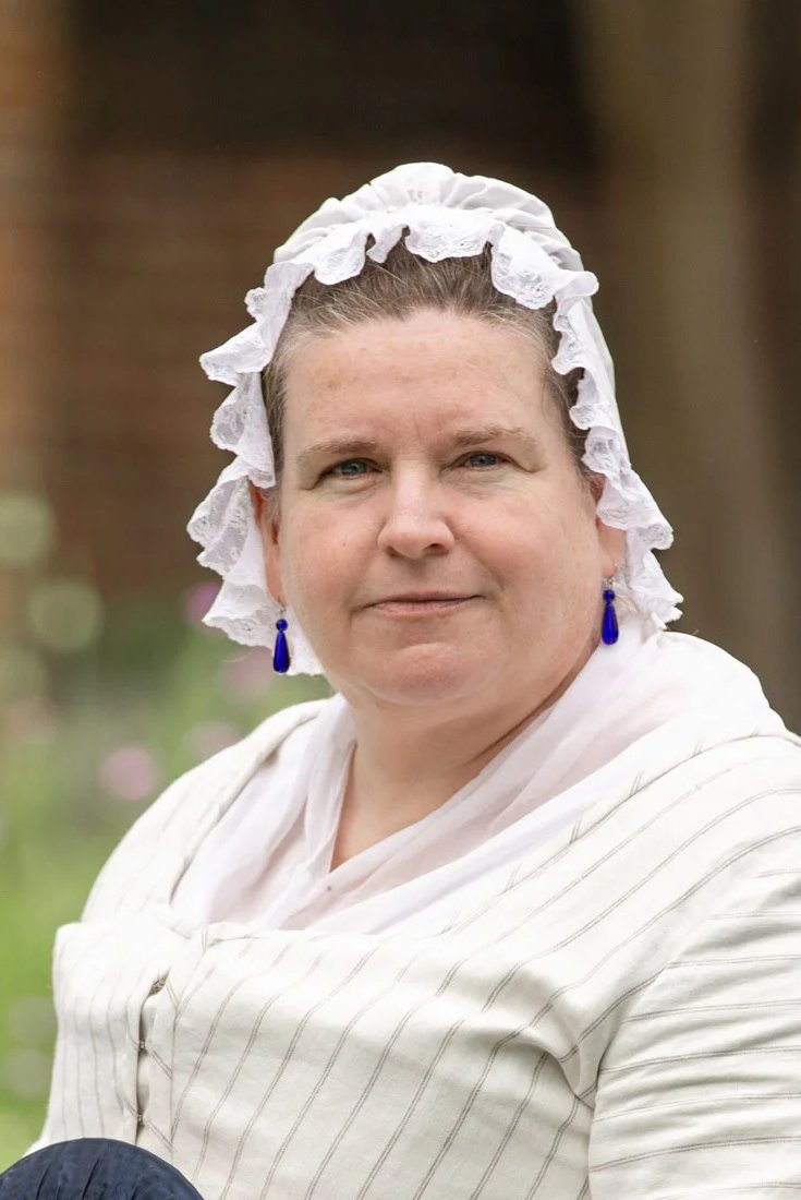 An interpreter dressed as Jane Vobe looks at the camera.
